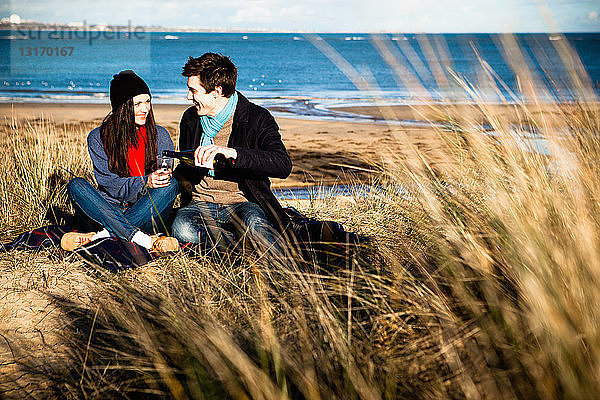 Ehepaar feiert mit Weißwein am Strand  Bournemouth  Dorset  UK