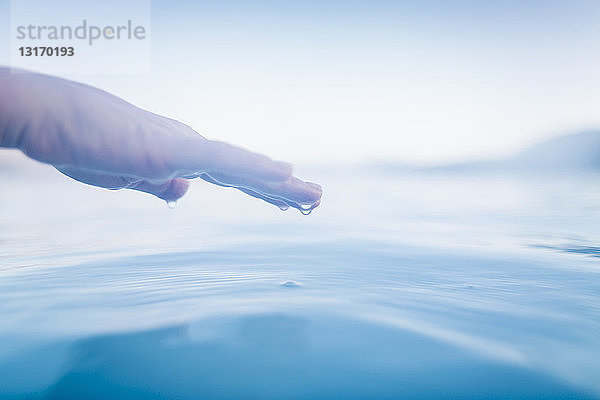 Hand über dem Oberflächenwasser der Lagune