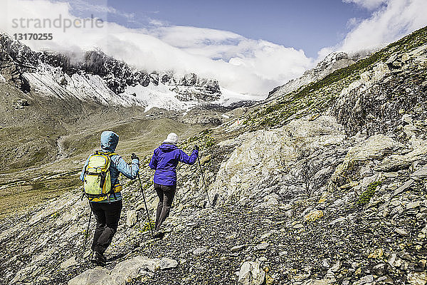 Zwei Wandererinnen wandern auf Felsen  Fil de Cassons  Segnesboden  Graubünden  Schweiz