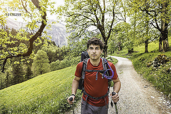 Junger Mann wandert die Landstraße hinauf  Oberstdorf  Bayern  Deutschland