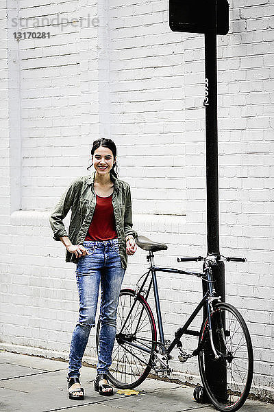 Frau steht neben Fahrrad