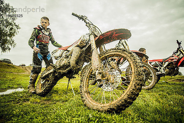 Zwei Jungen kontrollieren Motorräder beim Motocross