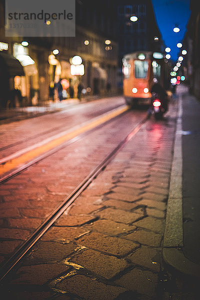 Straße mit herannahender Straßenbahn  bei Nacht  Mailand  Italien