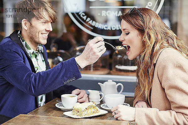 Mann füttert Freundin mit Kuchen im Bürgersteig-Café  London  Großbritannien