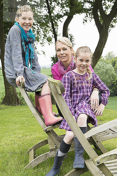 Mutter und Töchter auf Holzstuhl sitzend  Porträt