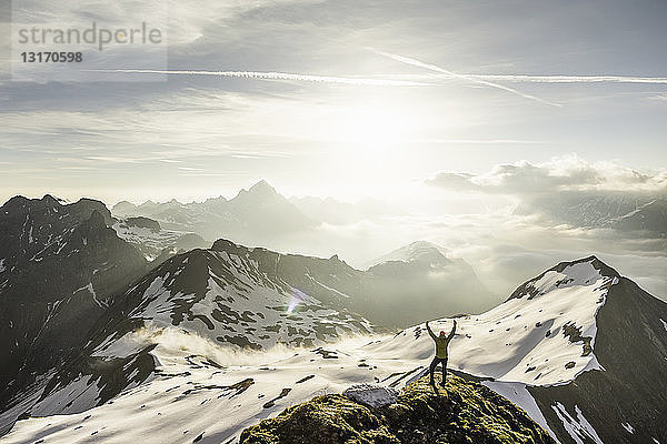 Junger männlicher Bergwanderer mit erhobenen Armen in den bayerischen Alpen  Oberstdorf  Bayern  Deutschland