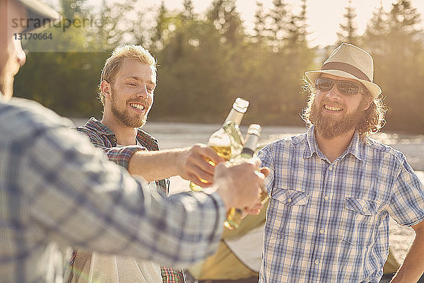 Männer  die mit Bierflaschen anstoßen  lächelnd