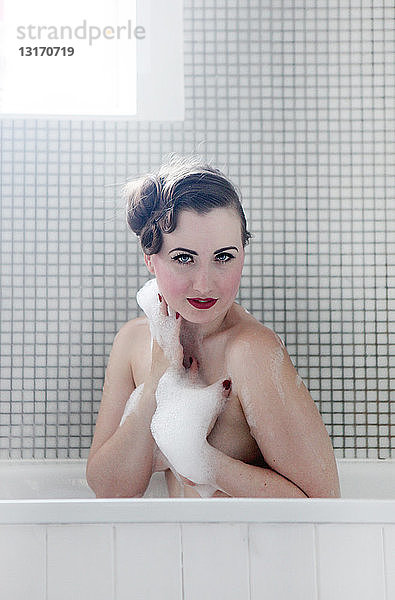 Junge Frau in der Badewanne  von Blasen bedeckt