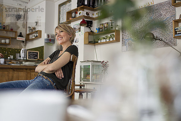 Mittlere erwachsene Frau  die im Café sitzt