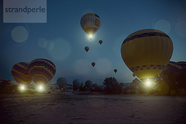 Beleuchtete Heißluftballons  die nachts in den Himmel steigen  Kappadokien  Anatolien  Türkei