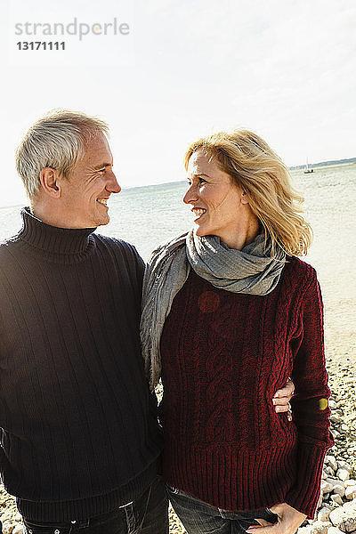 Ein erwachsenes Paar am See  von Angesicht zu Angesicht  lächelnd