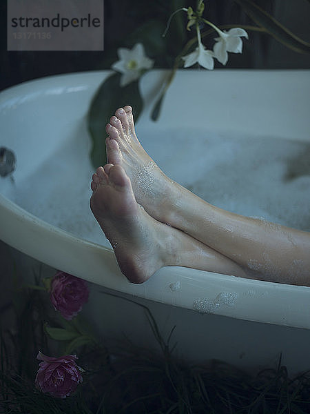 Junge Frau in Badewanne  Füße auf dem Wannenrand  Fokus auf Füße