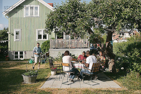 Mehrgenerationen-Familie isst während der Gartenparty auf der Terrasse