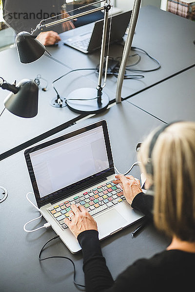 Geschäftsfrau mit Laptop am Schreibtisch im Büro
