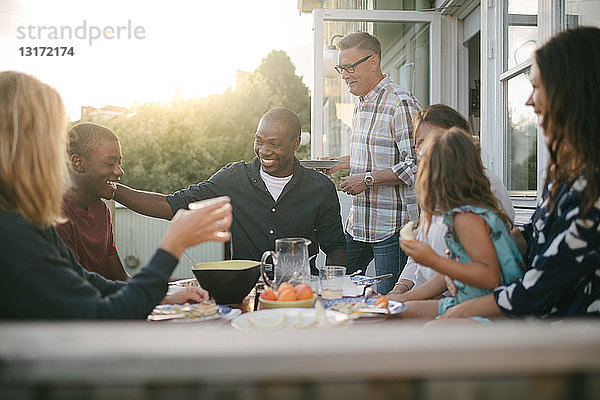 Fröhliche Mehrgenerationen-Familie genießt Mittagessen auf der Veranda