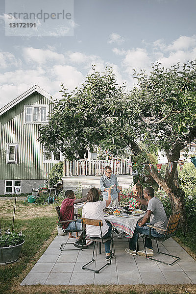 Mehrgenerationen-Familie trinkt während der Gartenparty auf der Terrasse
