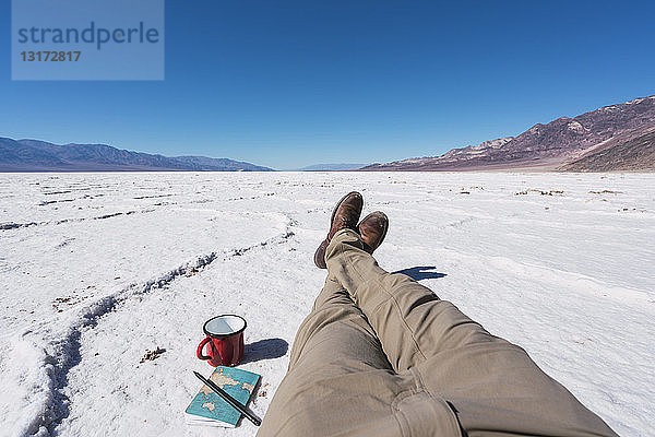 USA  Kalifornien  Death Valley  Beine eines Mannes  der eine Pause macht