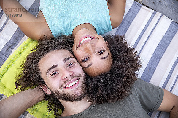Porträt eines glücklichen Paares  das im Freien auf einer Decke liegt