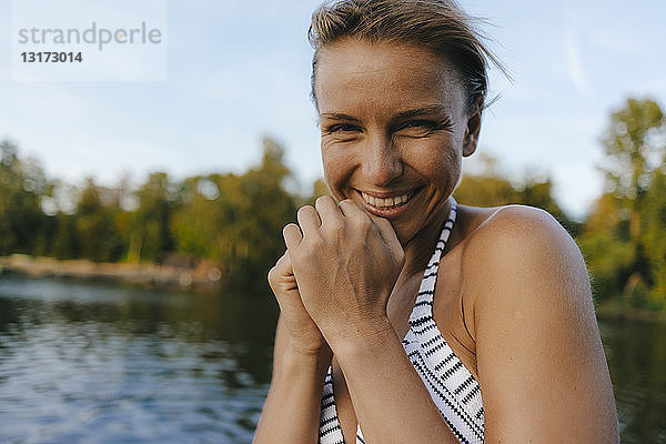 Porträt einer glücklichen Frau im Bikini an einem See