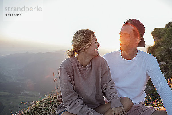 Schweiz  Grosse Mythen  glückliches junges Paar auf einer Wanderung mit Pause bei Sonnenaufgang