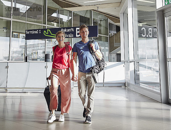 Glückliches Paar geht Hand in Hand auf dem Flughafen