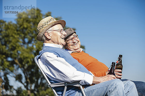 Zwei alte Freunde sitzen auf den Feldern  trinken Bier und reden über alte Zeiten