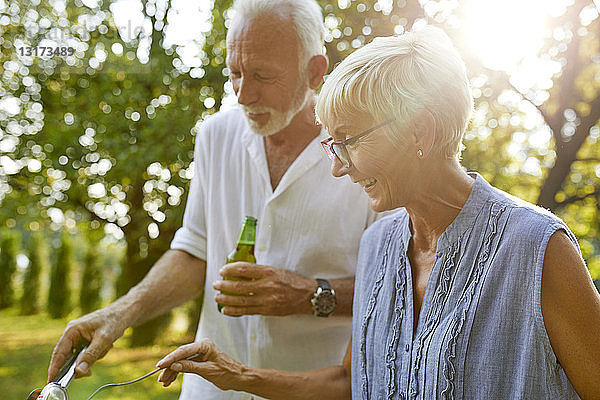 Älteres Ehepaar beim Grillen im Garten