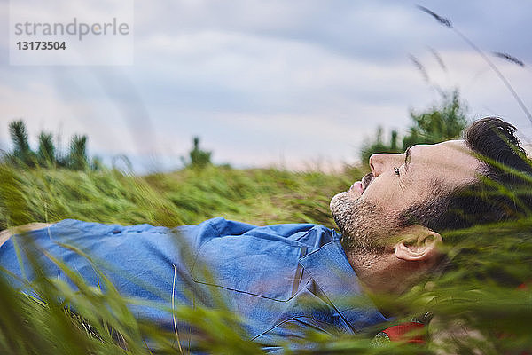 Entspannter Mann im Gras liegend