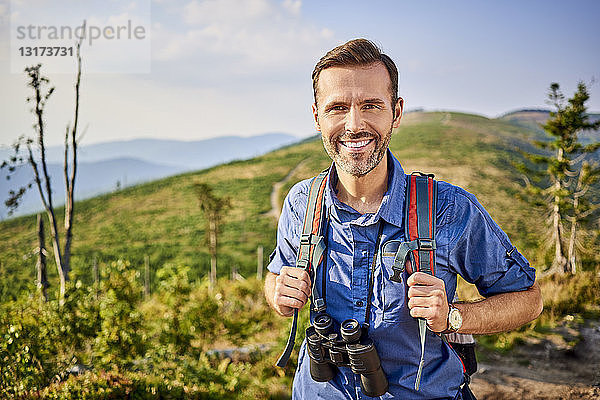 Porträt eines lächelnden Mannes beim Wandern in den Bergen