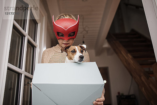 Junge mit Superhelden-Maske mit Jack Russel Terrier in