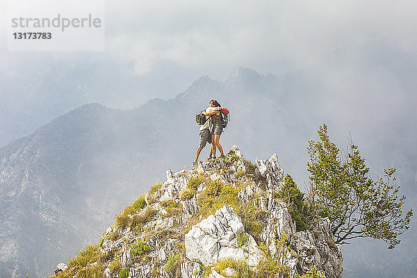 Italien  Massa  glückliches Paar umarmt sich auf einem Gipfel in den Alpi Apuane