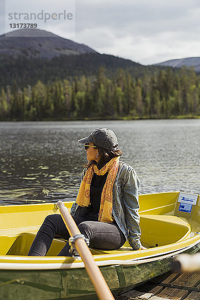 Finnland  Lappland  Frau sitzt in einem Boot auf einem See