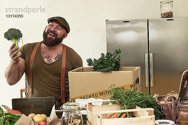 Reifer Mann mit Lieferservice verpackt Bio-Gemüse in Karton