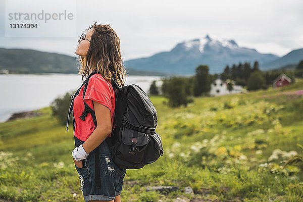 Junge Frau mit Rucksack im norwegischen Lappland unterwegs