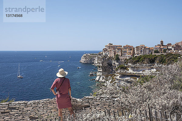 Korsika  Bonifacio  Frau steht auf einem Aussichtspunkt und schaut auf die Stadt