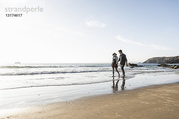 Frankreich  Bretagne  junges Paar geht Hand in Hand am Strand