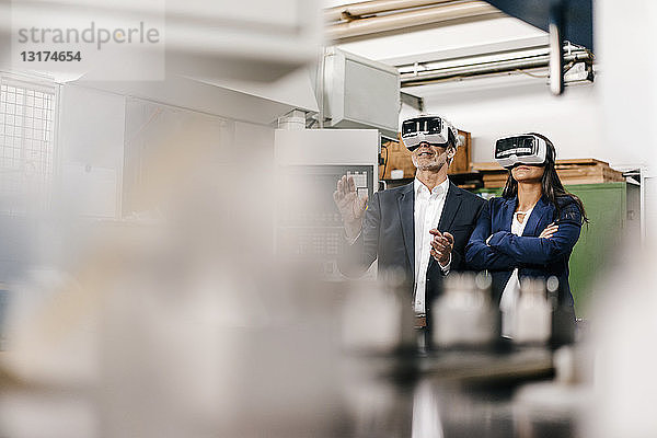 Geschäftsmann und Frau in einem High-Tech-Unternehmen mit VR-Brille