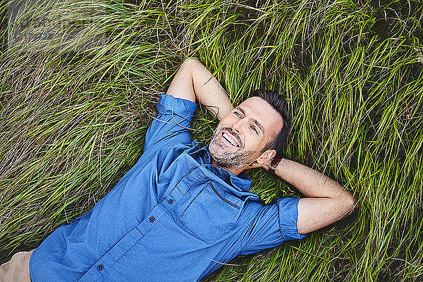 Entspannter glücklicher Mann liegt im Gras