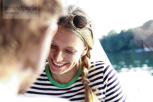 Lächelnde junge Frau mit Mann an einem See