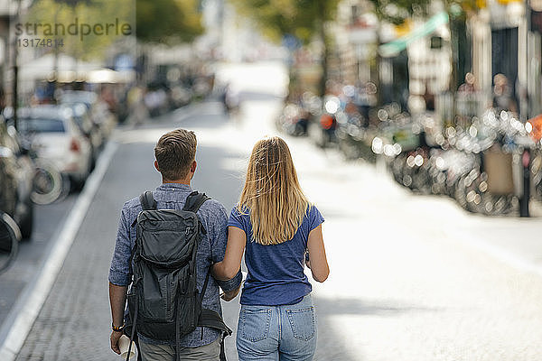 Niederlande  Maastricht  Rückansicht eines jungen Paares  das durch die Stadt läuft