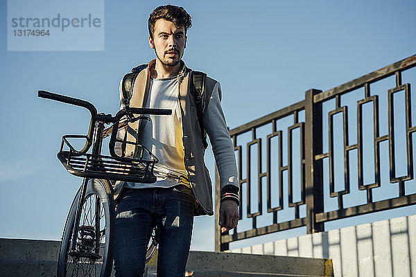 Junger Mann mit Pendler-Fixie-Fahrrad die Treppe hinunter