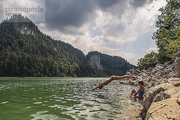 Österreich  Salzkammergut  Mondsee  Frau mit Tochter springt in See