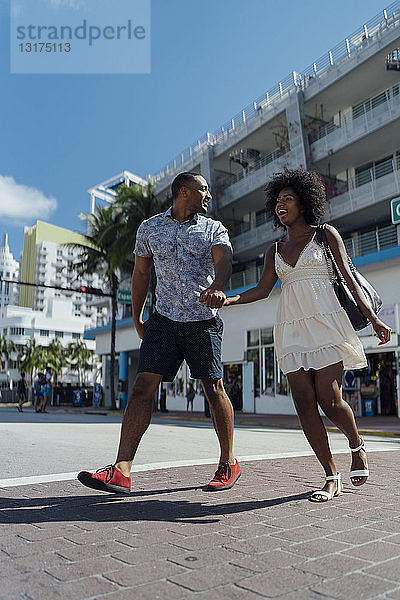 USA  Florida  Miami Beach  glückliches junges Paar beim Überqueren der Straße