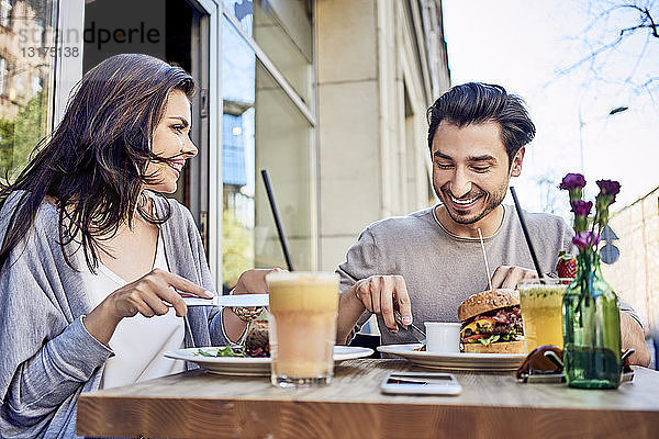 Glückliches junges Paar beim Mittagessen in einem Restaurant im Freien