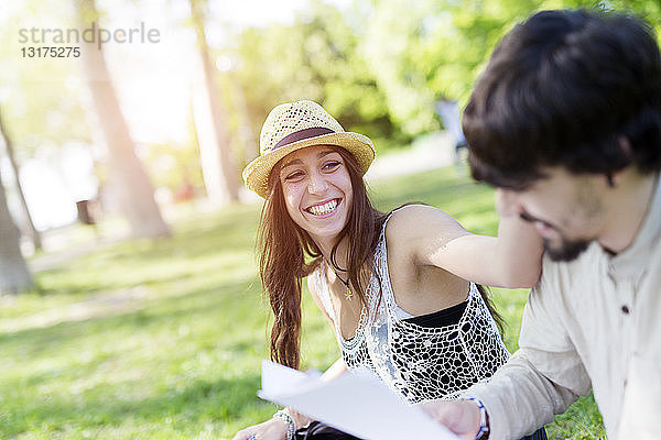 Porträt einer lachenden jungen Frau  die sich mit ihrer Kommilitonin in einem Park vergnügt