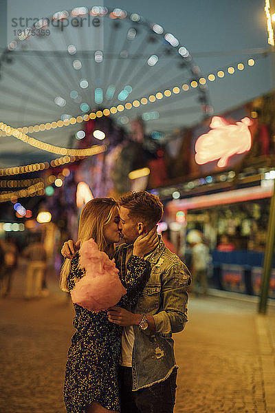 Romantisches Paar auf einem Jahrmarkt beim Essen von Zuckerwatte