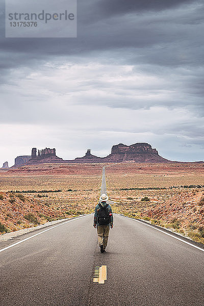 USA  Utah  Mann mit Rucksack auf der Straße zum Monument Valley