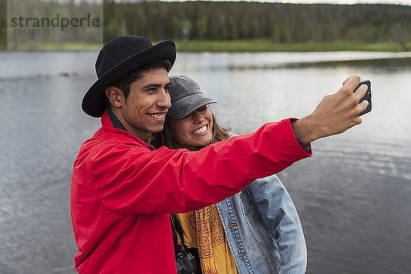 Finnland  Lappland  glückliches Paar beim Selbermachen an einem See