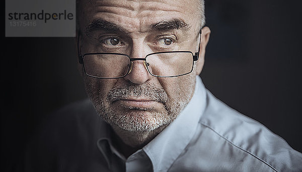Porträt eines seriös aussehenden älteren Mannes mit Brille