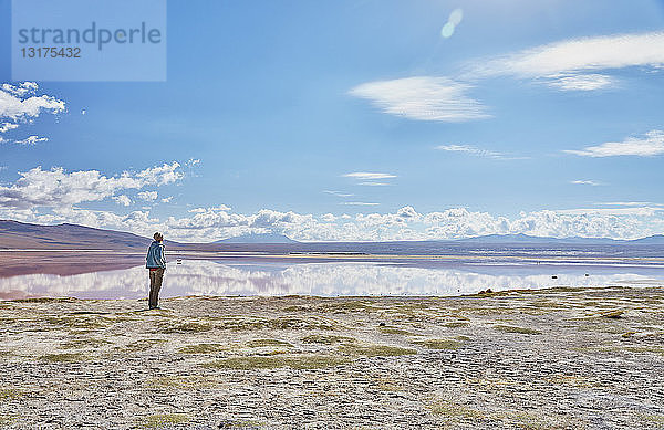 Bolivien  Laguna Colorada  Frau steht am Seeufer und schaut zu